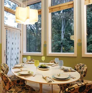 The breakfast room's oval Saarinen Table—designed so no one gets stuck sitting over a leg—was given a restored Formica finish. Natural hemp slipcovers on the chairs, in Galbraith and Paul's "Donuts" fabric, feature hand-applied natural dyes.